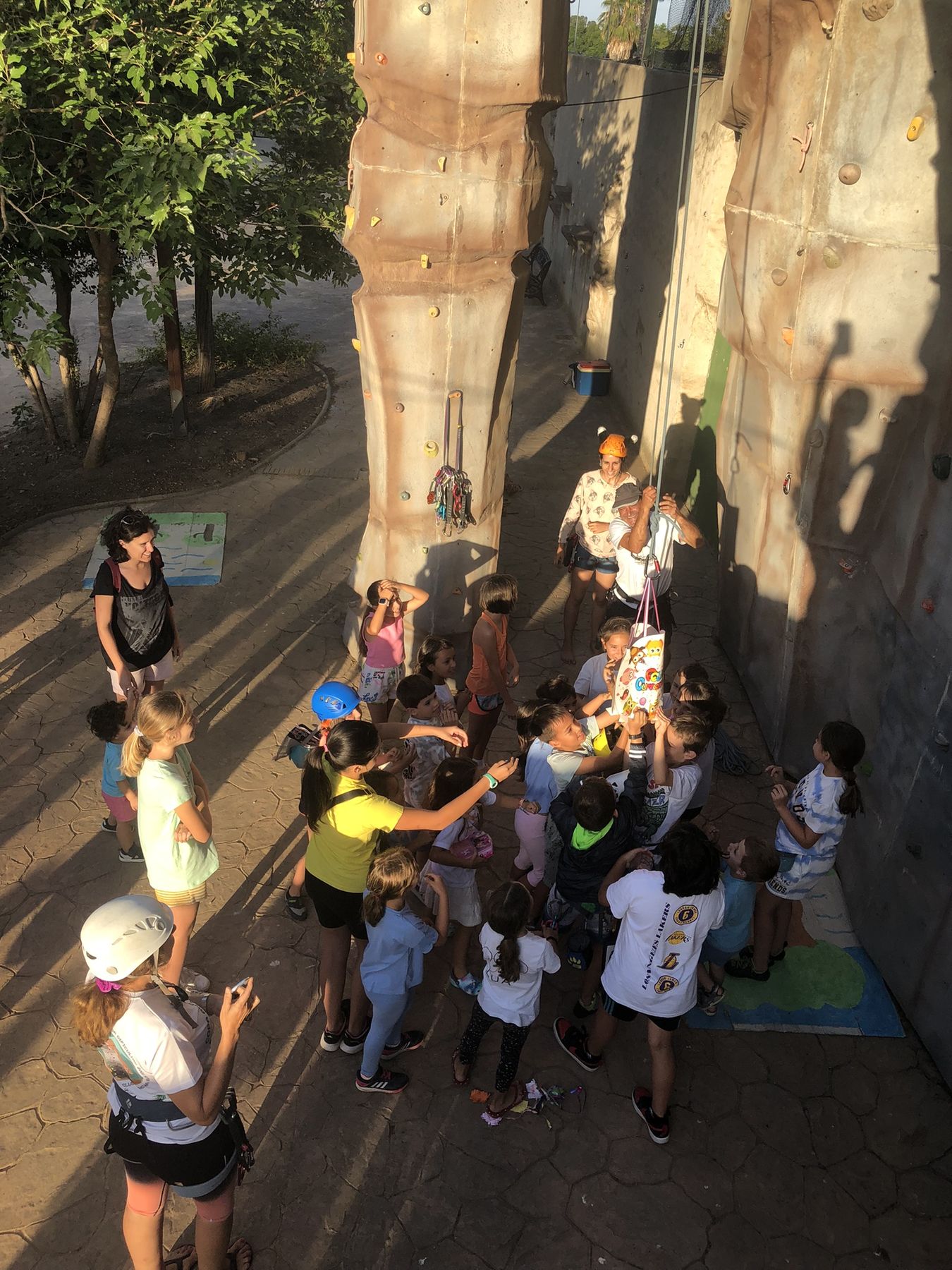 Niños y familias al pie de la pared en la fiesta de fin de curso del taller